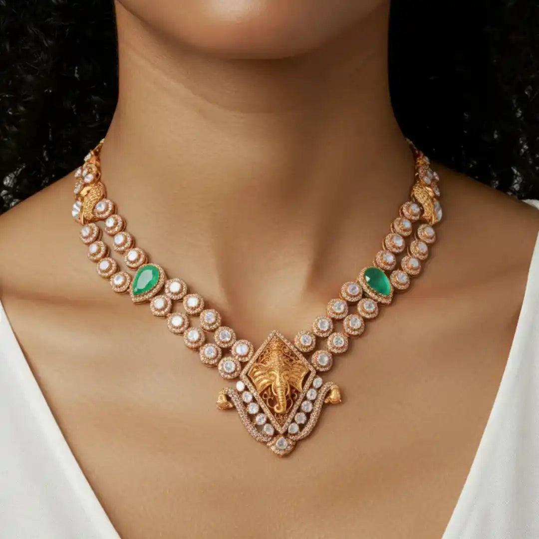 Elegant gold necklace with elephant motif, emerald stones, and diamond accents for women