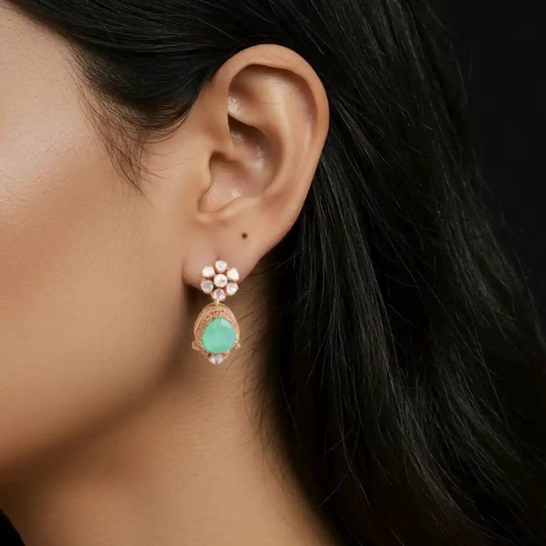 Elegant silver earring with green stone and floral design, perfect for traditional or festive wear.