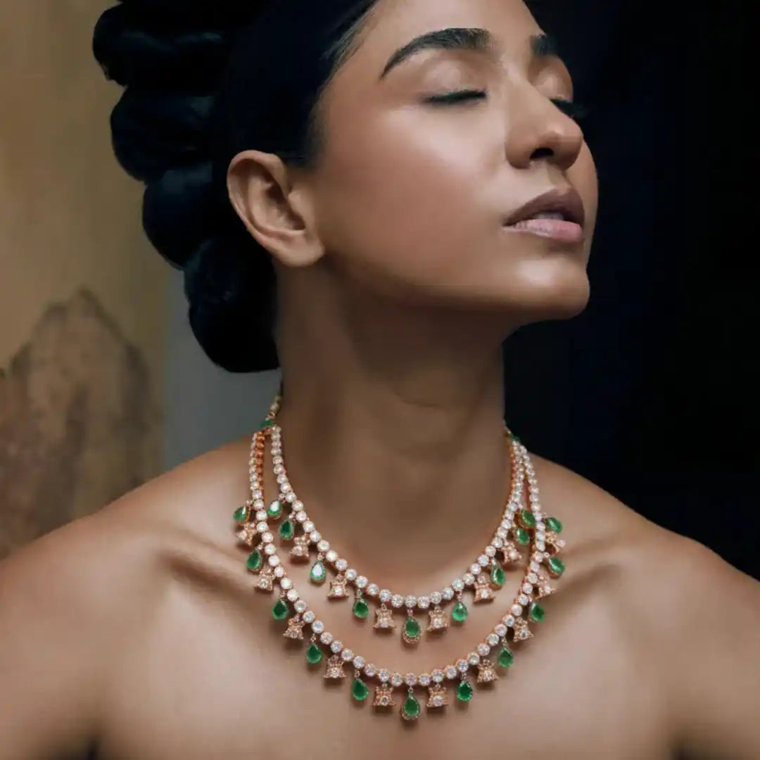 Elegant multi-tiered necklace with emerald drops and diamond accents, showcasing luxury silver jewelry design.