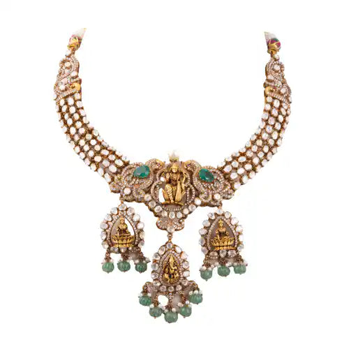 Elegant silver necklace with Ganesha motifs, emerald accents, and pearl detailing for traditional wear