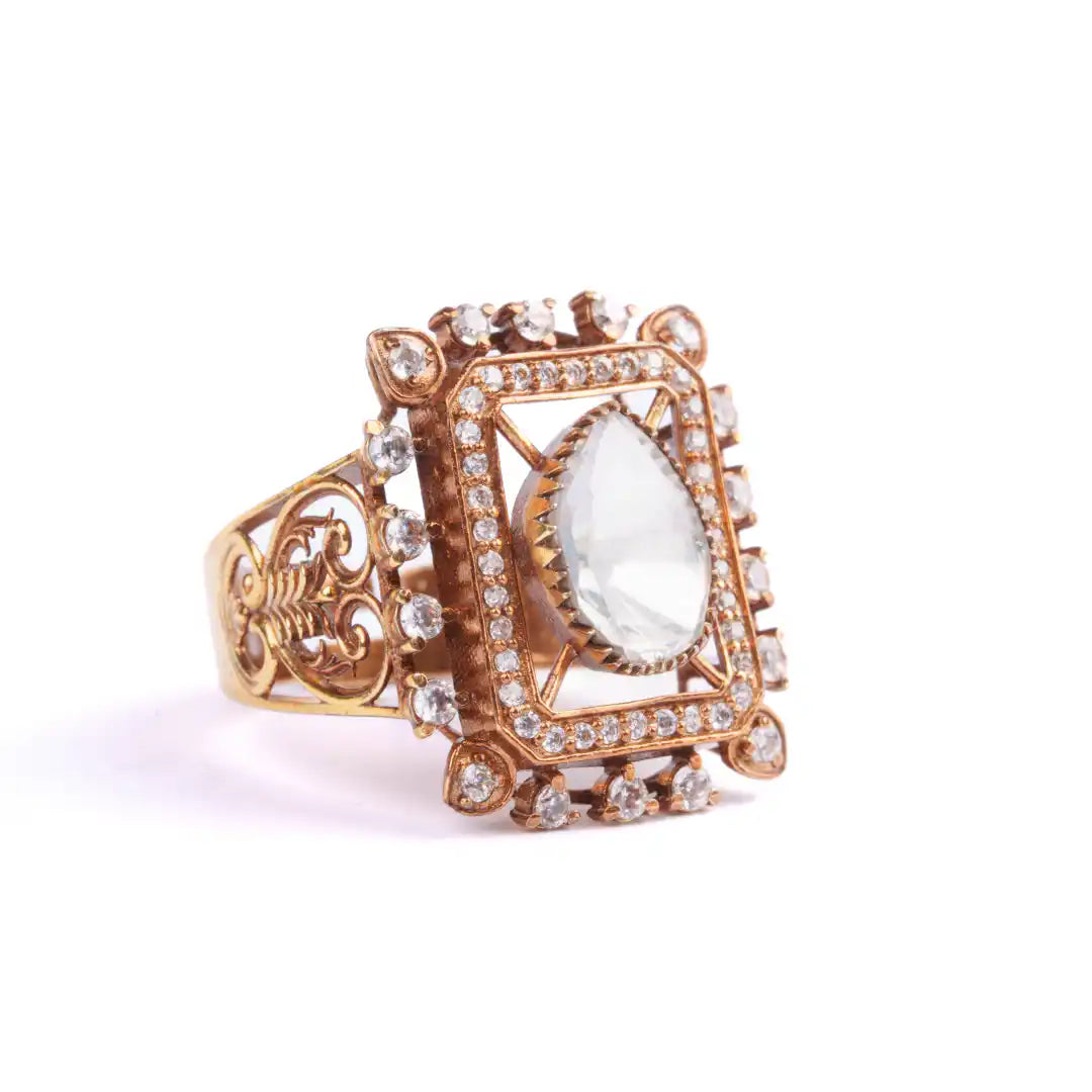 Elegant gold ring with pear-cut gemstone and diamond accents, vintage-inspired design