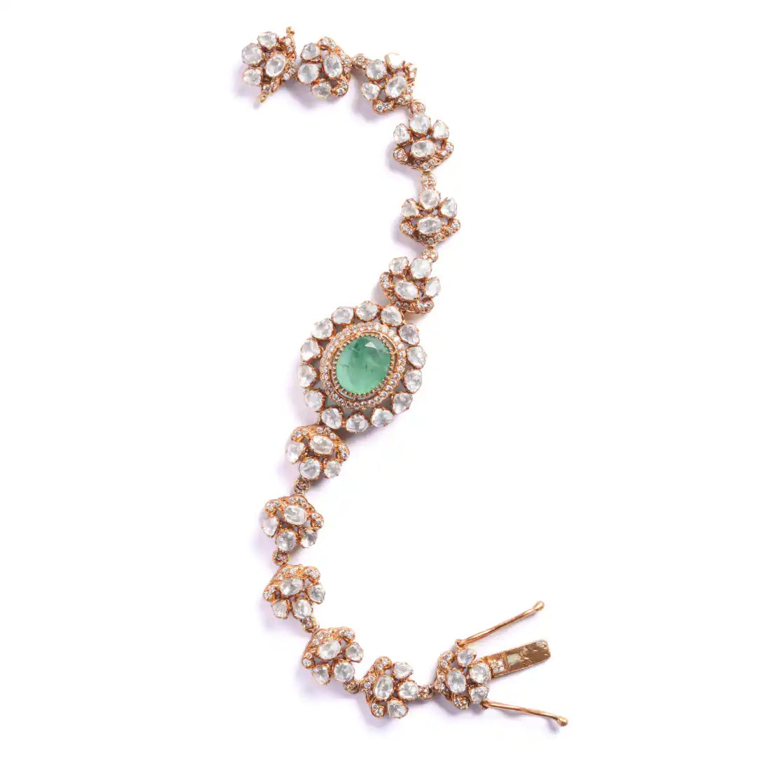 Elegant silver bracelet with emerald center and diamond accents, inspired by Ganesha's wisdom