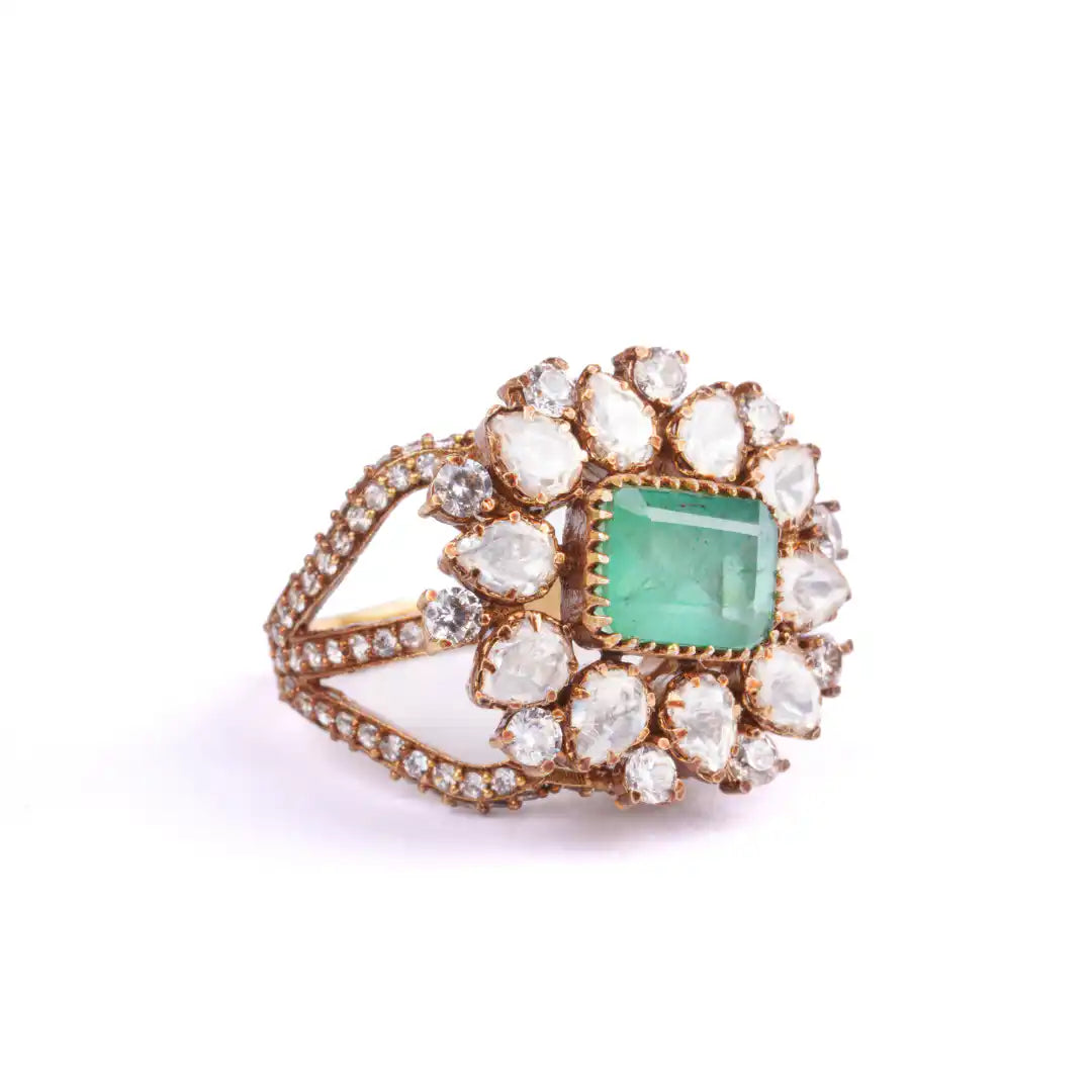 Emerald and diamond cluster ring in gold, elegant vintage-inspired design with floral motif