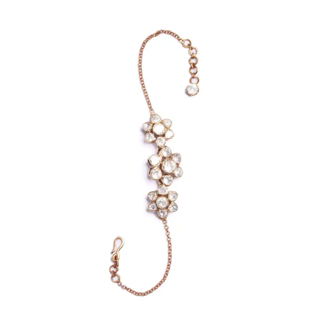 Elegant gold-tone hand chain with floral crystal design, perfect for traditional or festive wear.