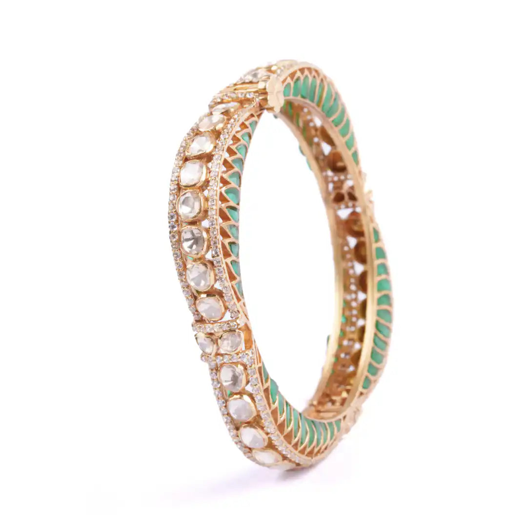 Gold bangle with green enamel and clear gemstones, intricate filigree design