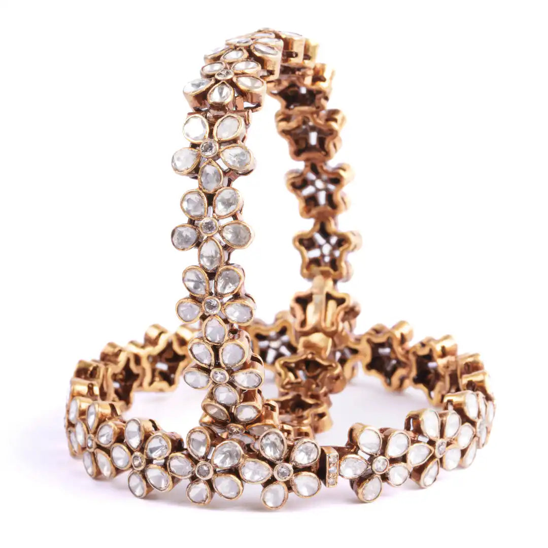 Gold-plated floral bangles with clear kundan stones, elegant traditional Indian jewelry