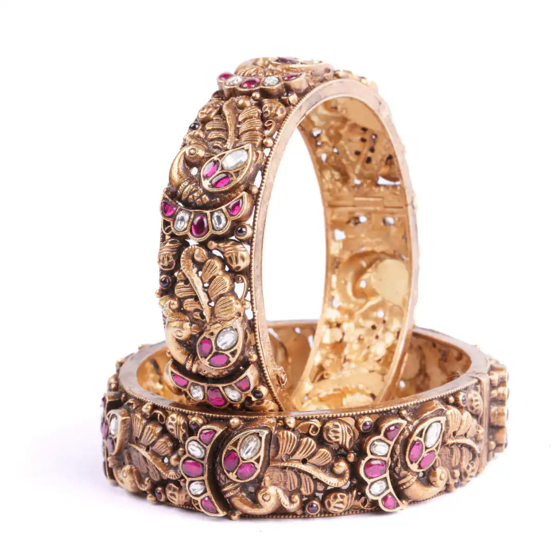 Intricate gold bangles with ruby and diamond accents, ornate peacock design, traditional Indian jewelry