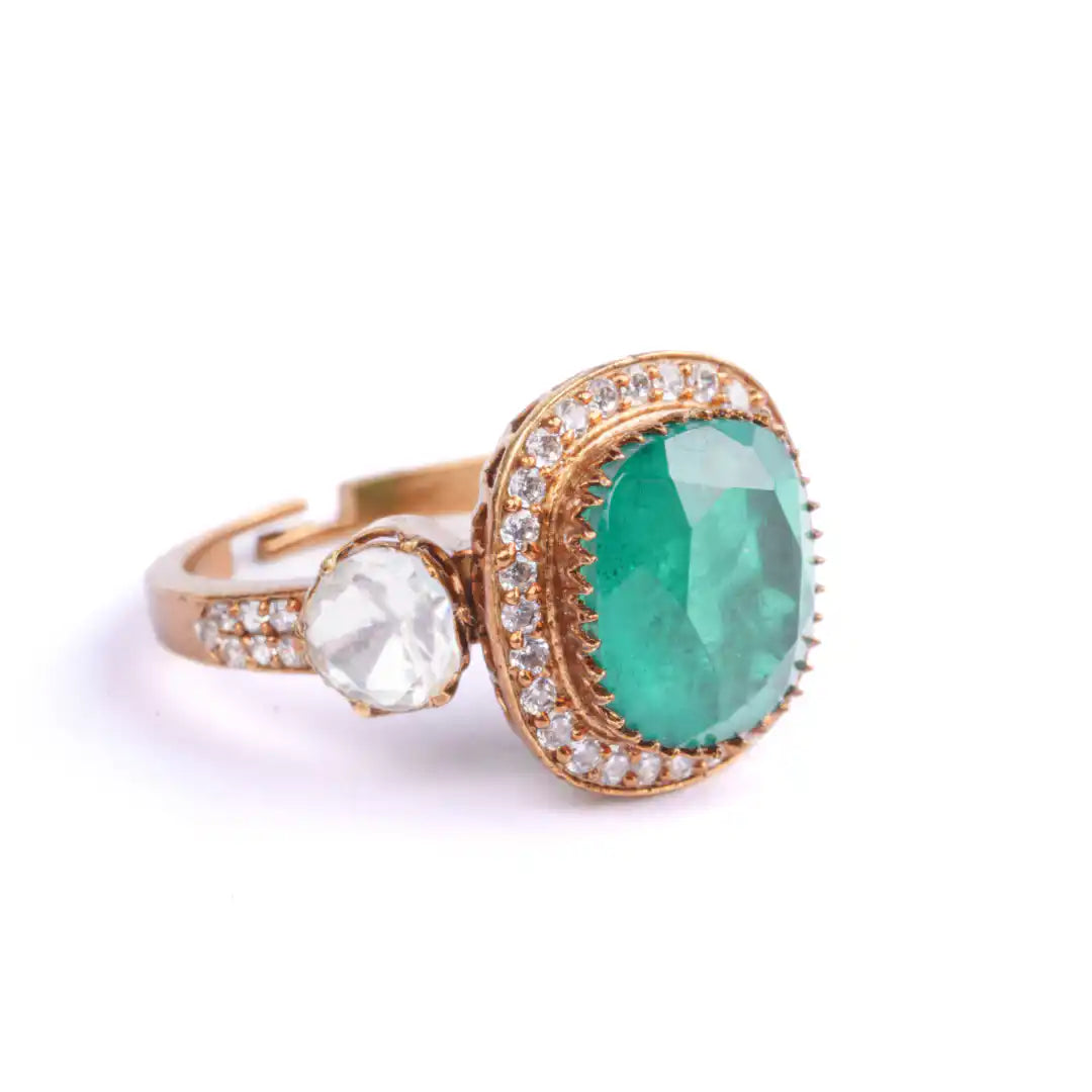 Elegant emerald and diamond ring with gold setting, showcasing luxury jewelry design.
