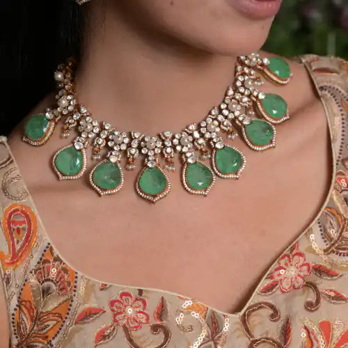 Elegant silver necklace with green gemstones and pearl accents, perfect for traditional Indian wear.