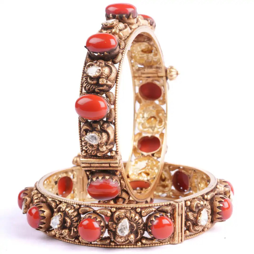 Gold bangle with red coral and clear gemstones, intricate filigree design, traditional Indian jewelry