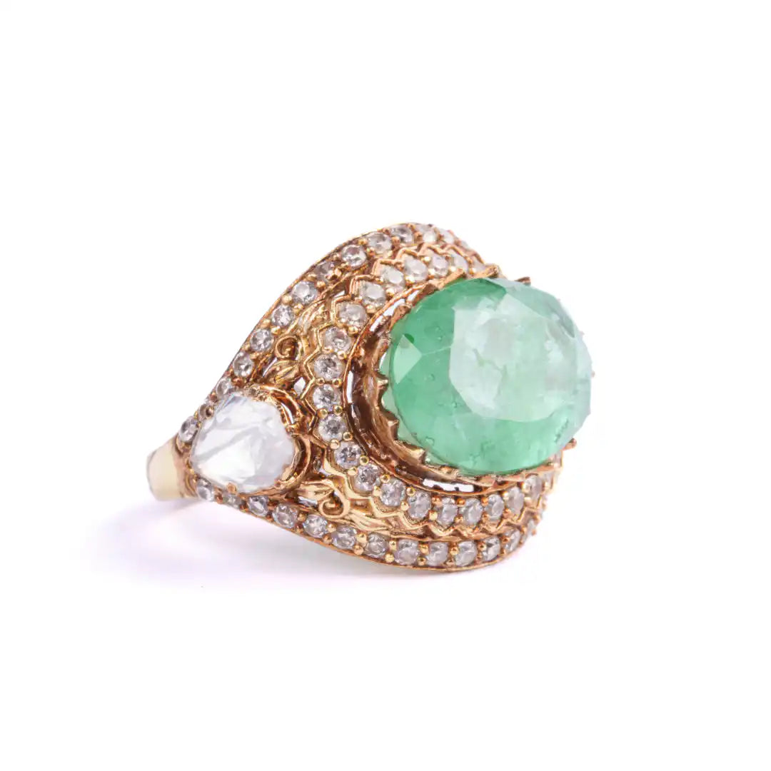 Elegant gold ring with emerald and diamond accents, showcasing intricate craftsmanship and luxury design.