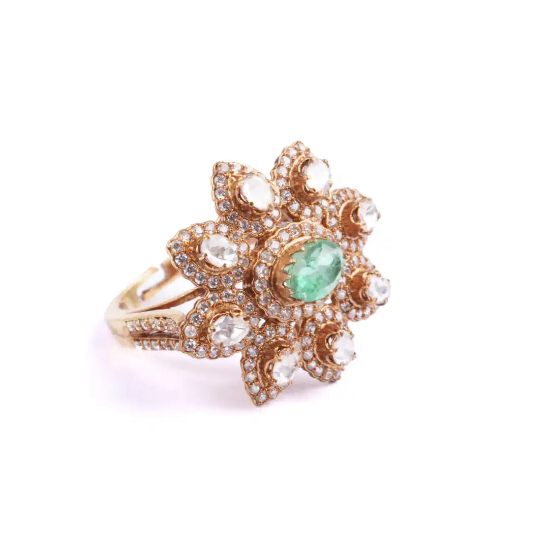 Floral gold ring with emerald center and diamond accents, elegant silver jewelry design