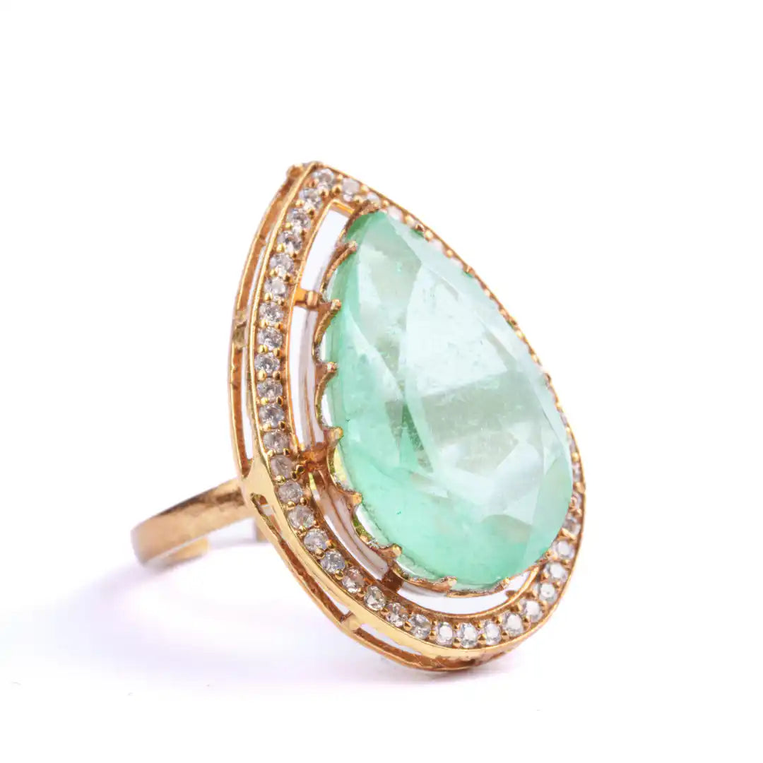 Elegant gold ring with pear-cut emerald and diamond accents, perfect for luxury jewelry lovers.