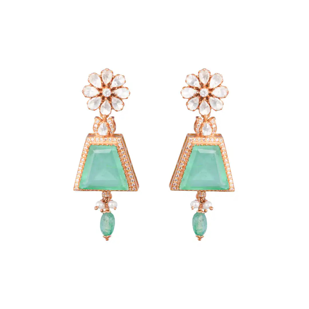 Elegant silver earrings with green gemstones, floral crystal tops, and pearl accents, perfect for traditional or festive wear.