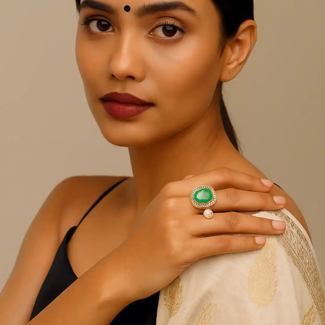 Elegant woman wearing a green gemstone ring with diamond accents, styled with traditional attire.