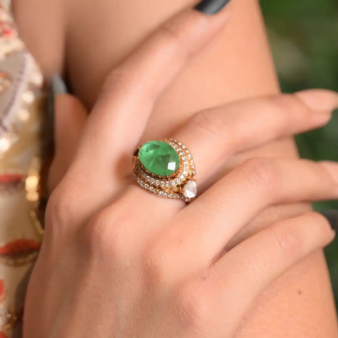 Elegant emerald ring with diamond accents on woman's hand, luxury silver jewelry