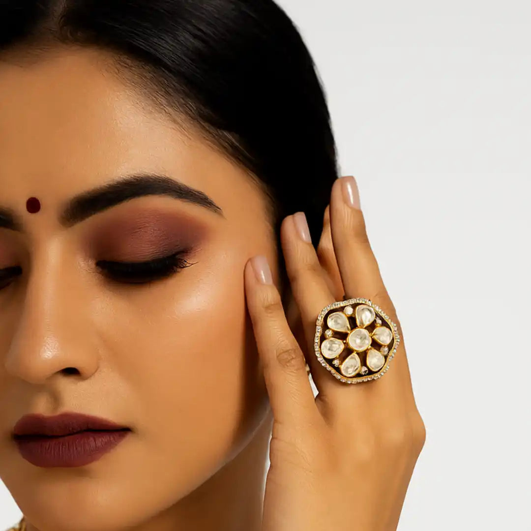 Elegant floral ring with white stones and gold detailing, worn by woman with traditional makeup
