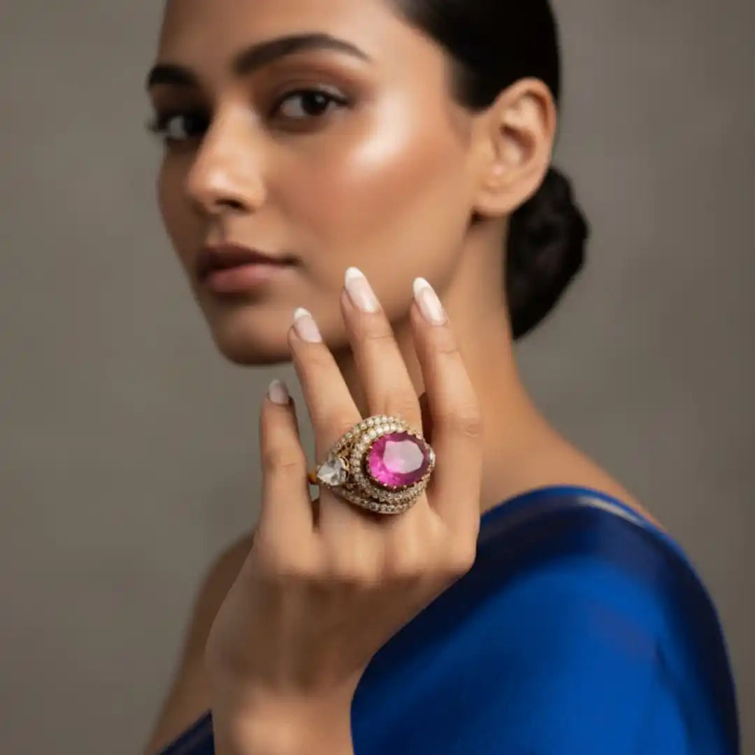 Elegant woman showcasing a luxurious ring with a large pink gemstone and diamond accents.