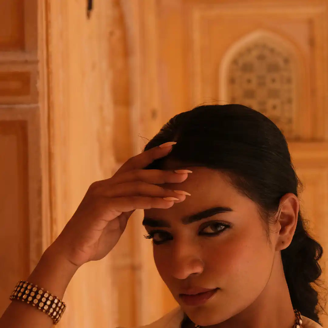 Woman wearing elegant silver bracelet with traditional Indian architecture background