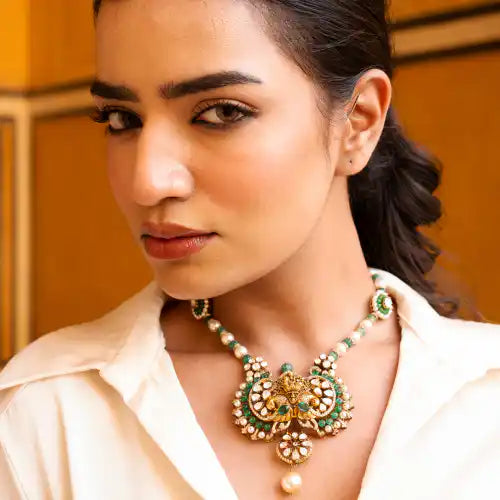 Elegant silver necklace with green gemstones and pearl accents, inspired by Ganesha's wisdom