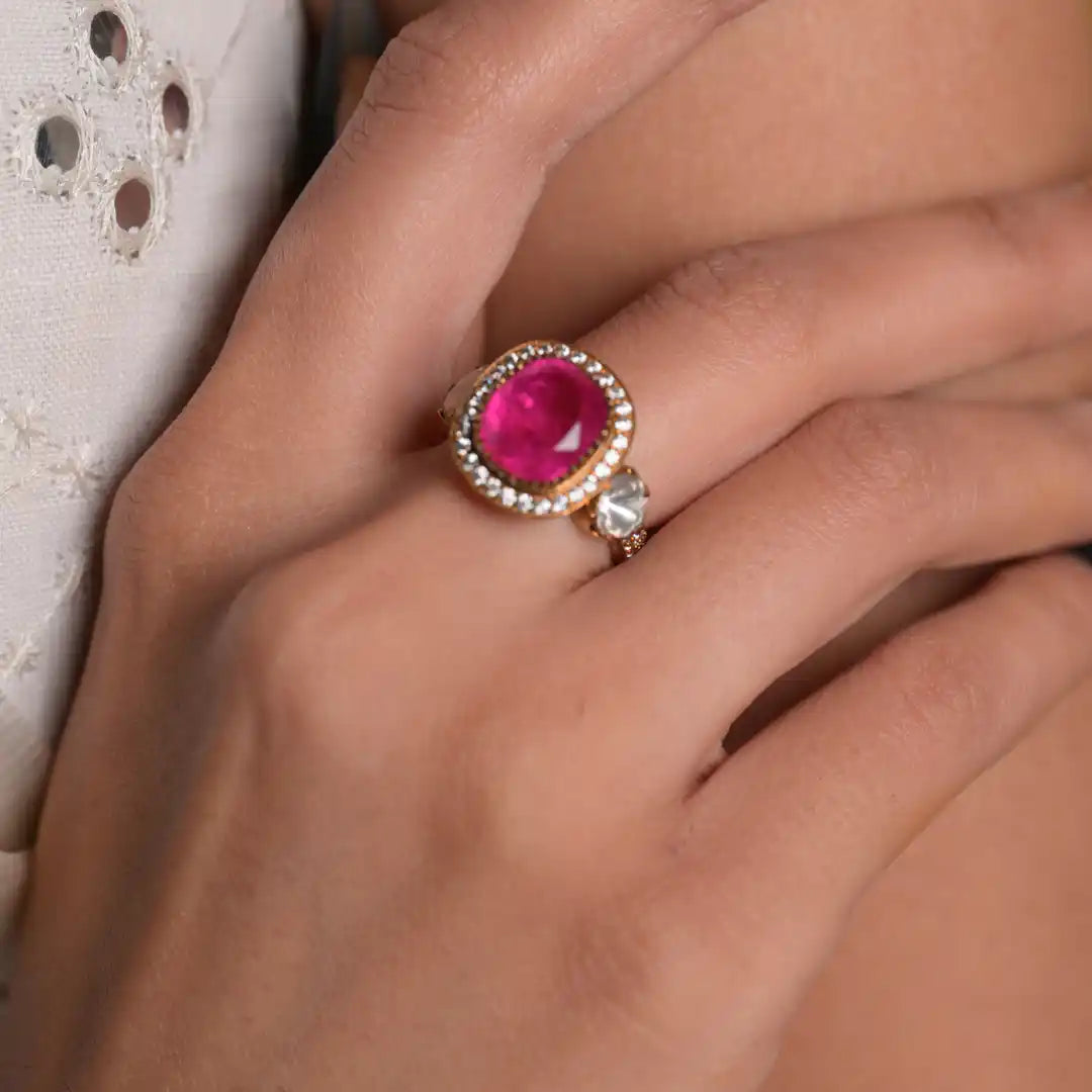 Elegant pink gemstone ring with diamond halo, worn on finger, showcasing luxury silver jewelry design.