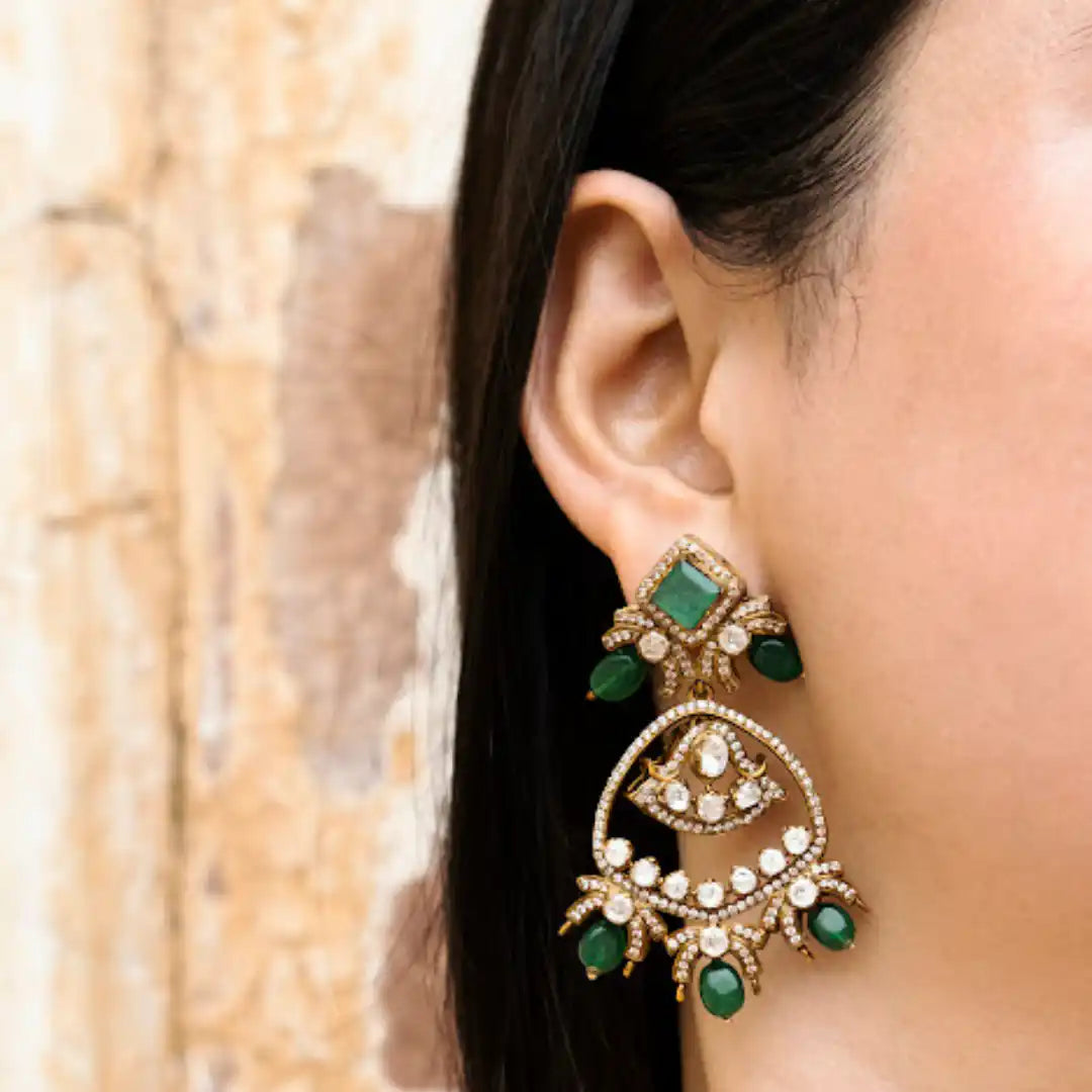 Elegant emerald and diamond chandelier earrings with intricate gold detailing, perfect for festive occasions.