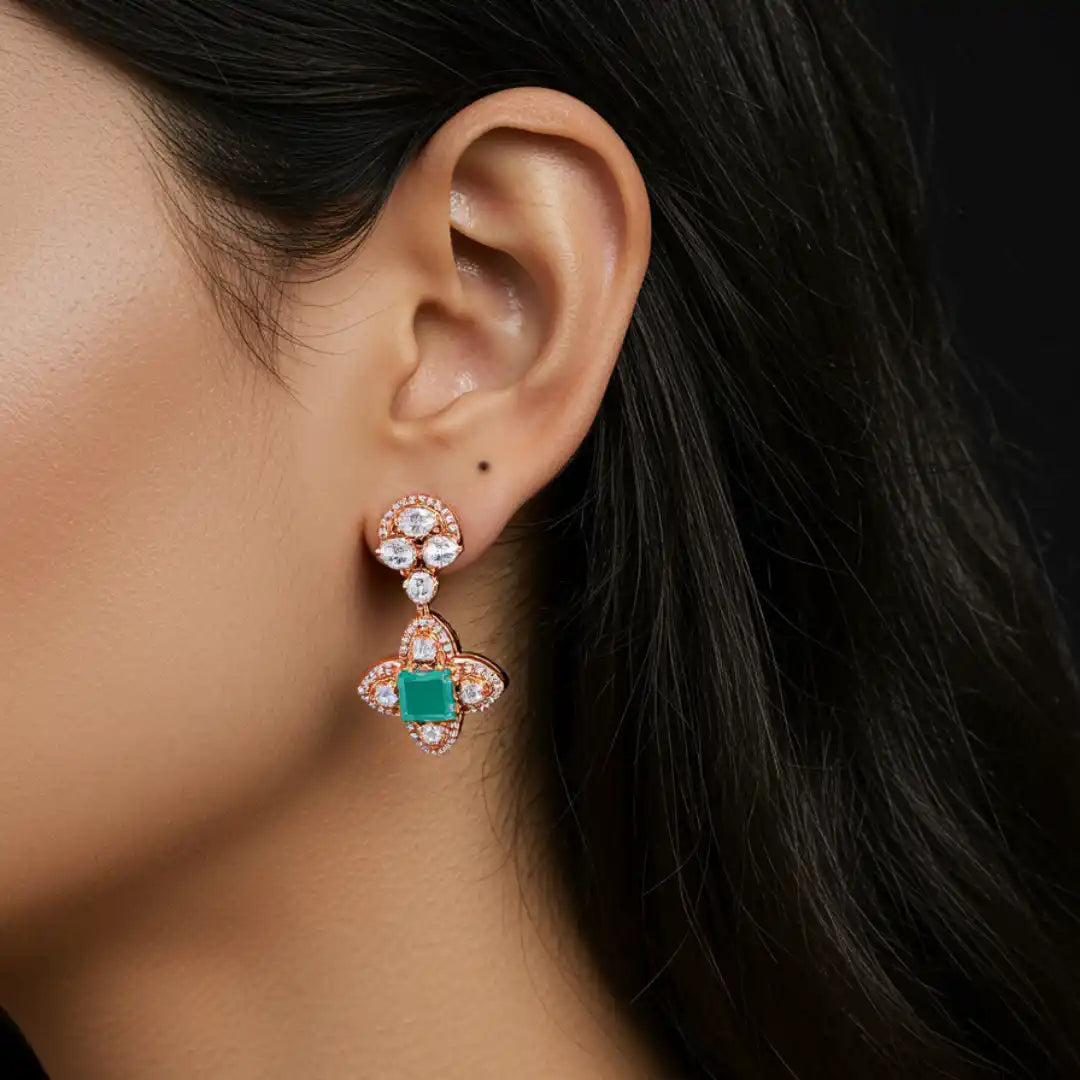 Elegant rose gold earrings with emerald and diamond accents, showcasing luxury silver jewelry design.