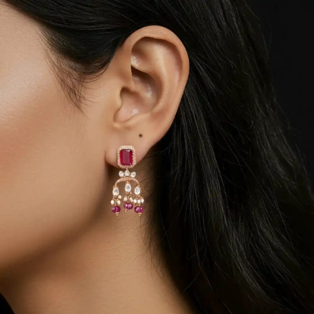 Elegant ruby and diamond chandelier earring with pearl drops, showcasing intricate silver jewelry design.