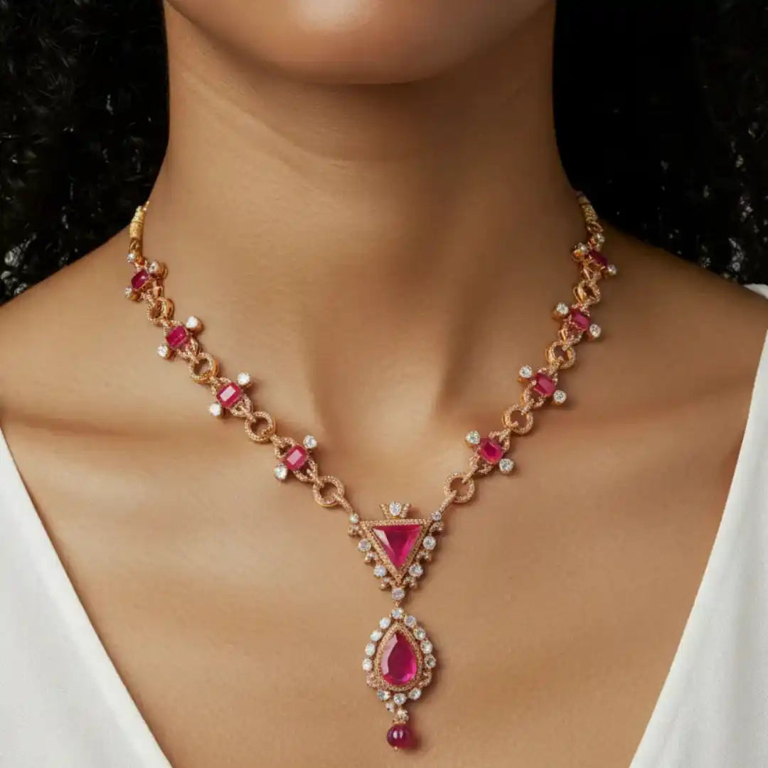 Elegant ruby and diamond necklace with rose gold chain, featuring triangular and teardrop gemstones for luxury bridal wear.