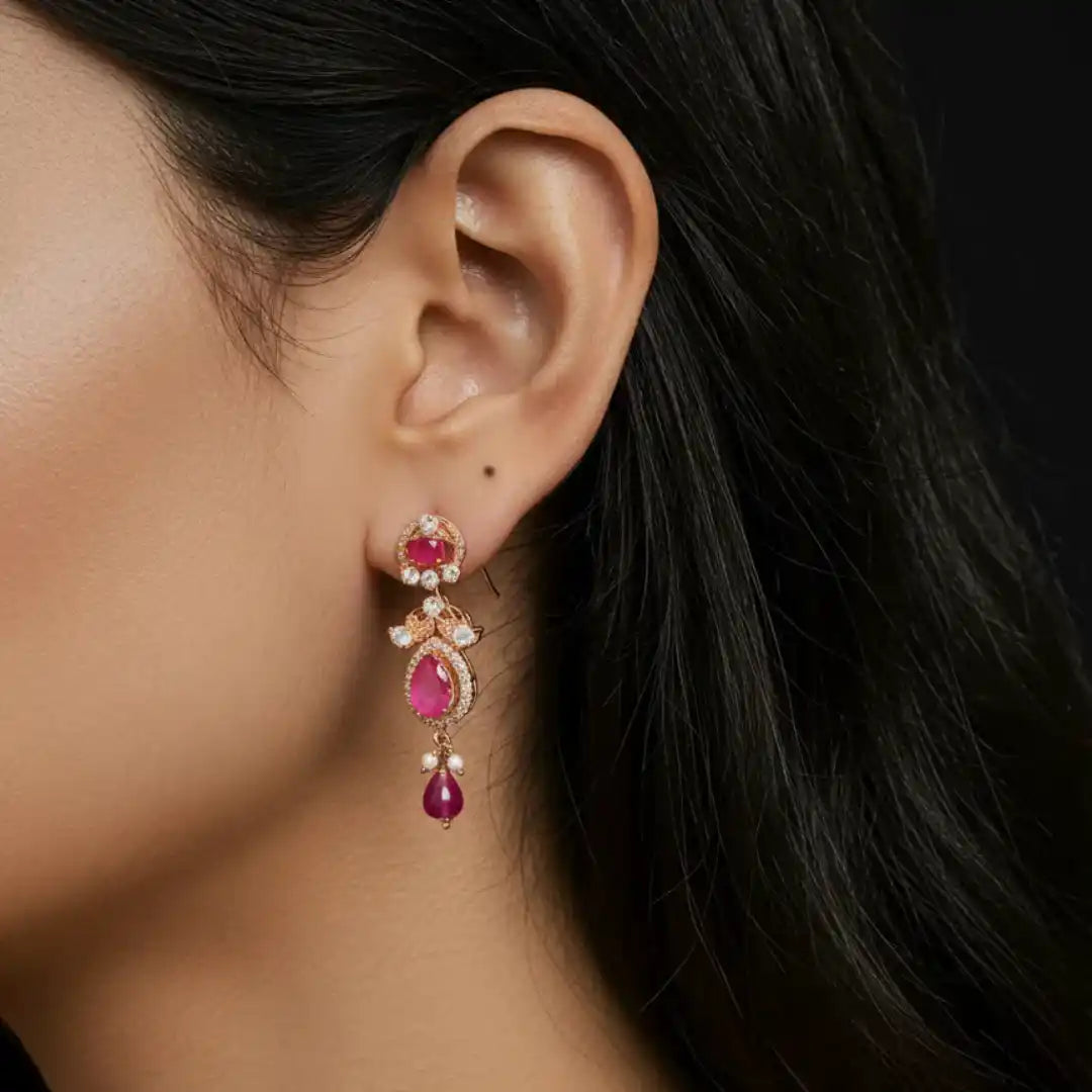 Elegant ruby and diamond drop earrings with pearl accents, showcasing luxury jewelry design.